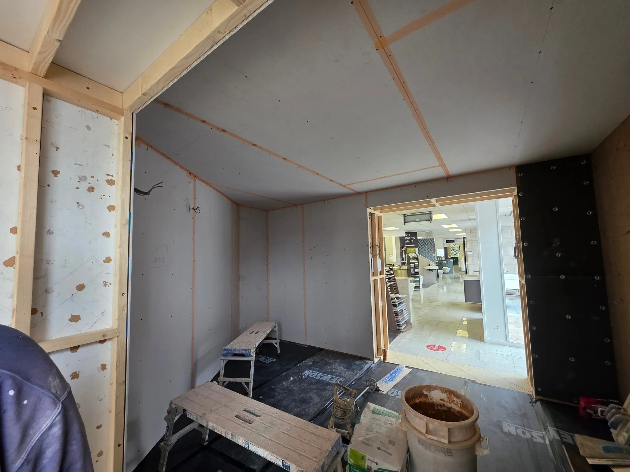 Plasterboard being fixed to a battened wall, ready for skimming.
