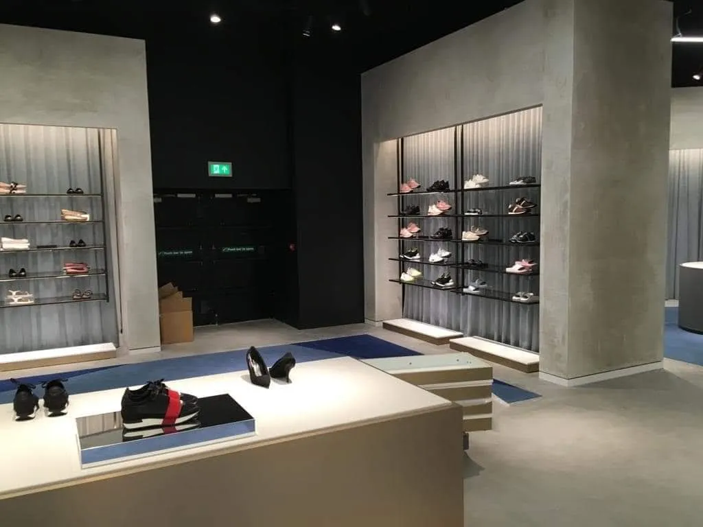 A shop display plinth and shelving set against smooth plastered walls.